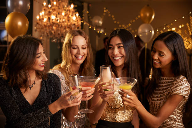 Group of friends celebrating with drinks at home, showing Bachelorette DIY Party Ideas on a budget.