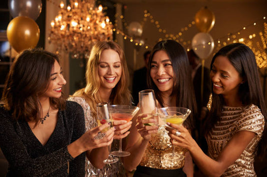 Group of friends celebrating with drinks at home, showing Bachelorette DIY Party Ideas on a budget.